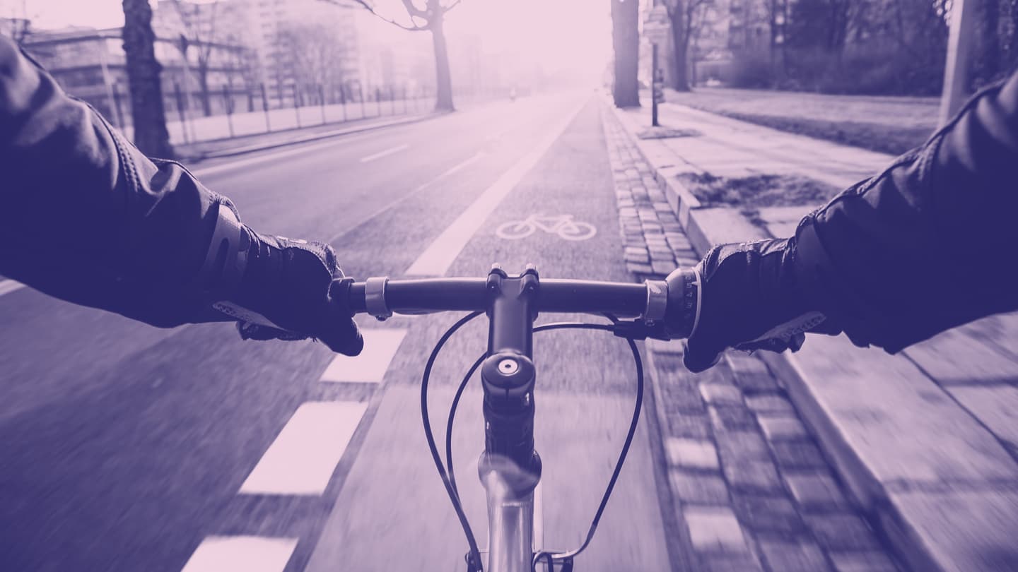 Colorized photo of a person riding a bicycle on a city street, featured in Finding the way forward